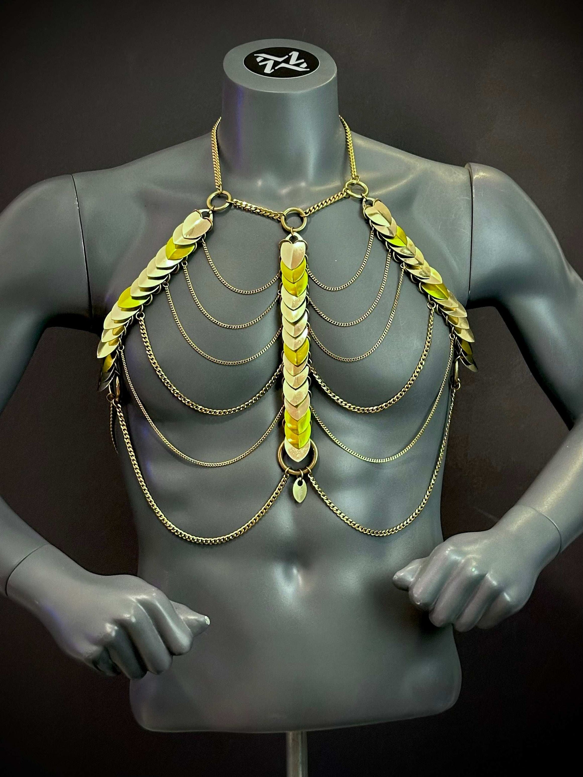 Gold chain body harness with metallic scales on gray mannequin, edgy and bold style