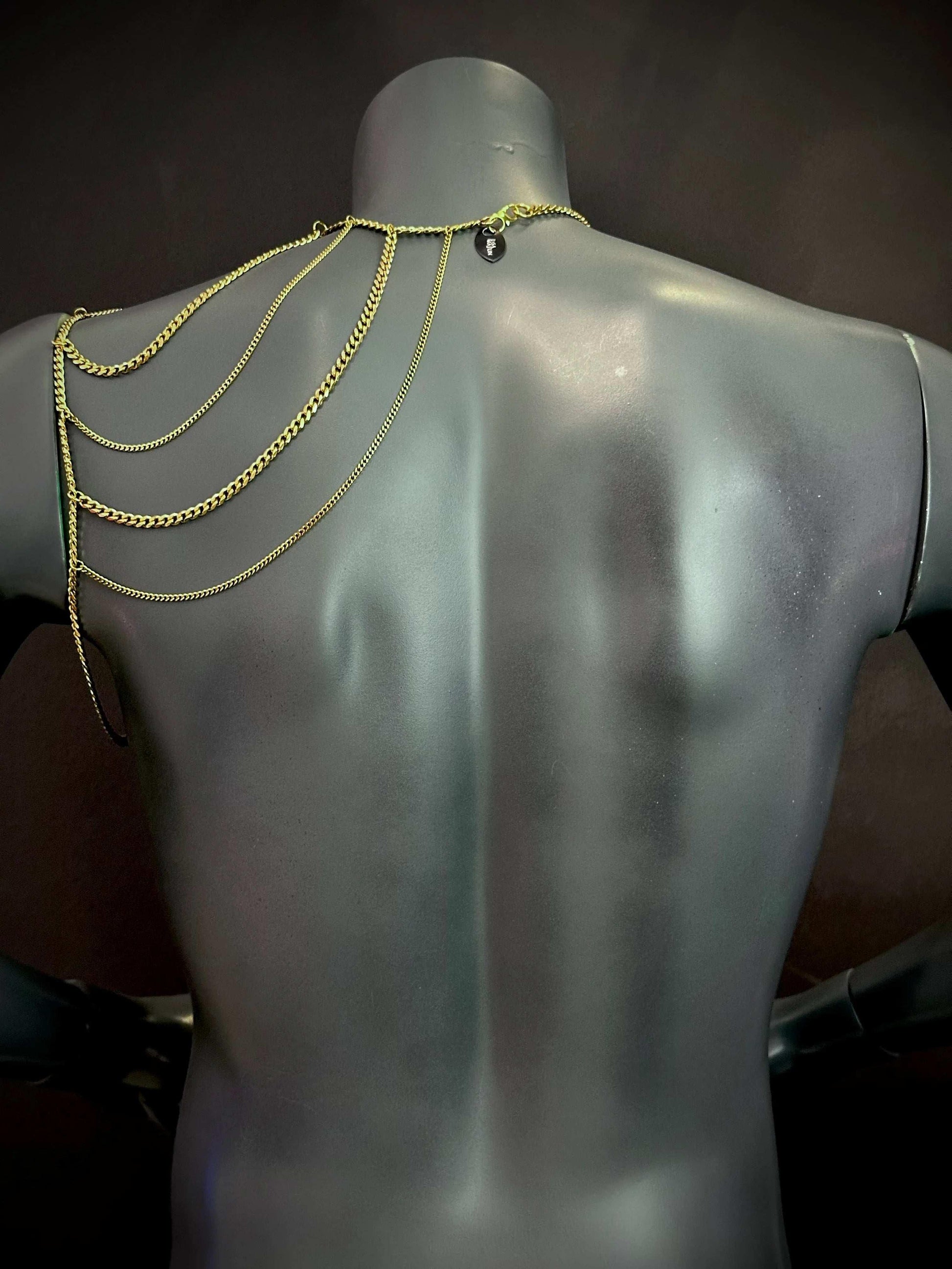gold chain jewelry draped on matte gray mannequin back, elegant and stylish