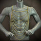 gold chain body harness on gray mannequin, modern style, elegant and bold