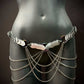 metal body chain in silver with iridescent rings and cascading chains on black mannequin, edgy and bold style