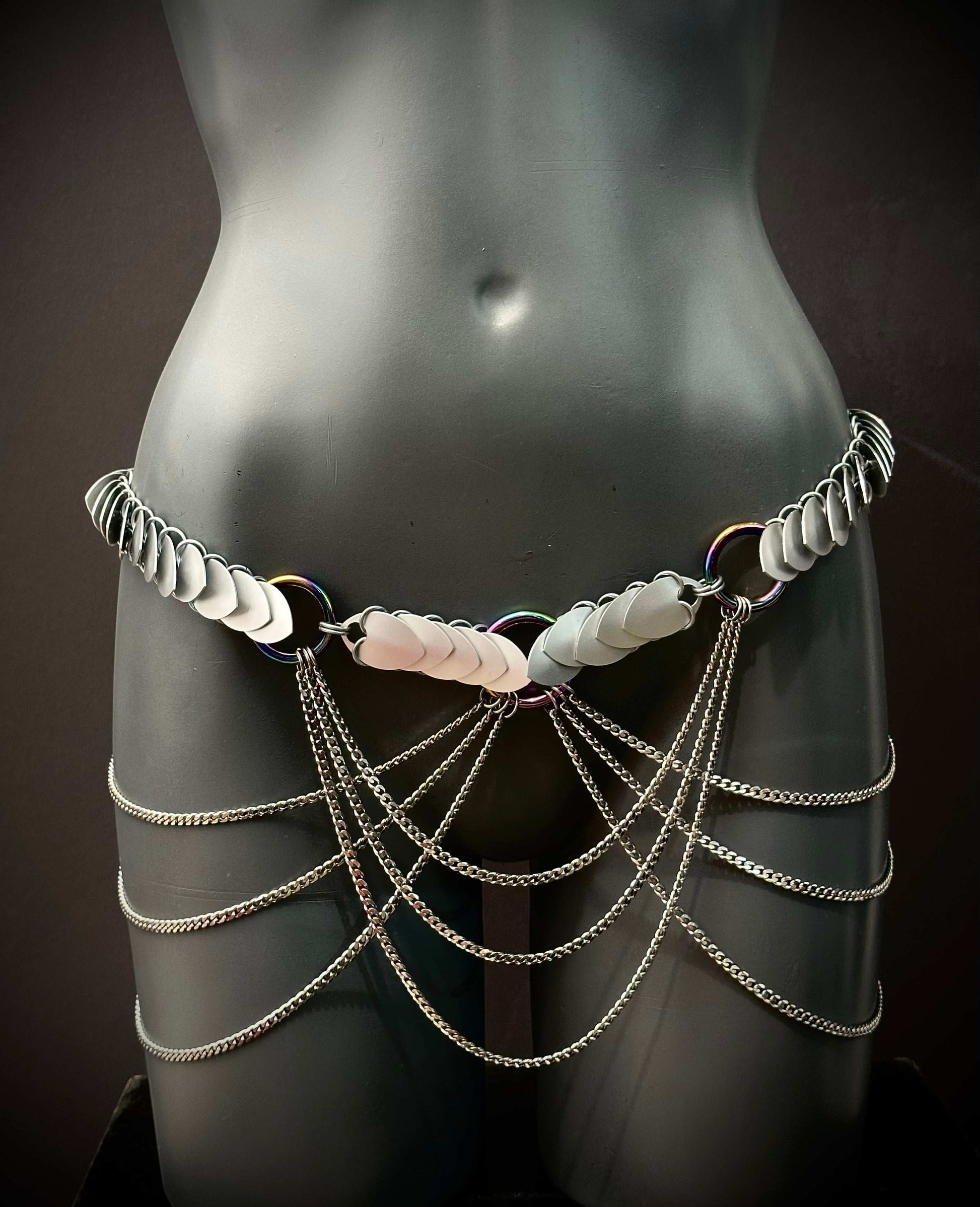 metal body chain in silver with iridescent rings and cascading chains on black mannequin, edgy and bold style