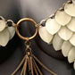Statement necklace with white leaf-shaped pieces and gold chains, elegant and edgy style