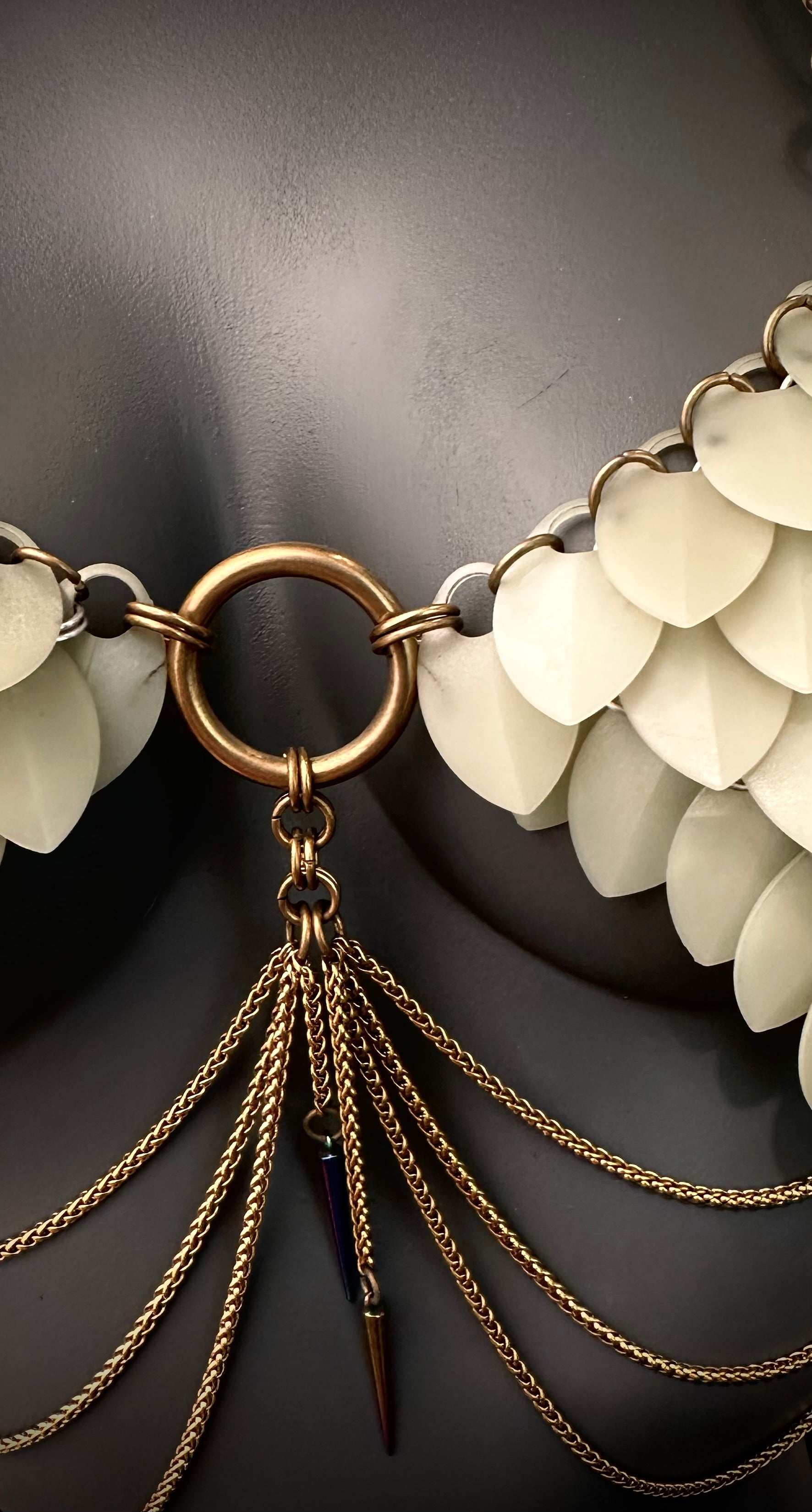 Statement necklace with white leaf-shaped pieces and gold chains, elegant and edgy style