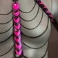 chain harness with pink and black scale design and black metal chains on gray mannequin, edgy and bold style