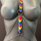 Rainbow heart body chain with multicolor links and brass rings on gray mannequin, bold and joyful