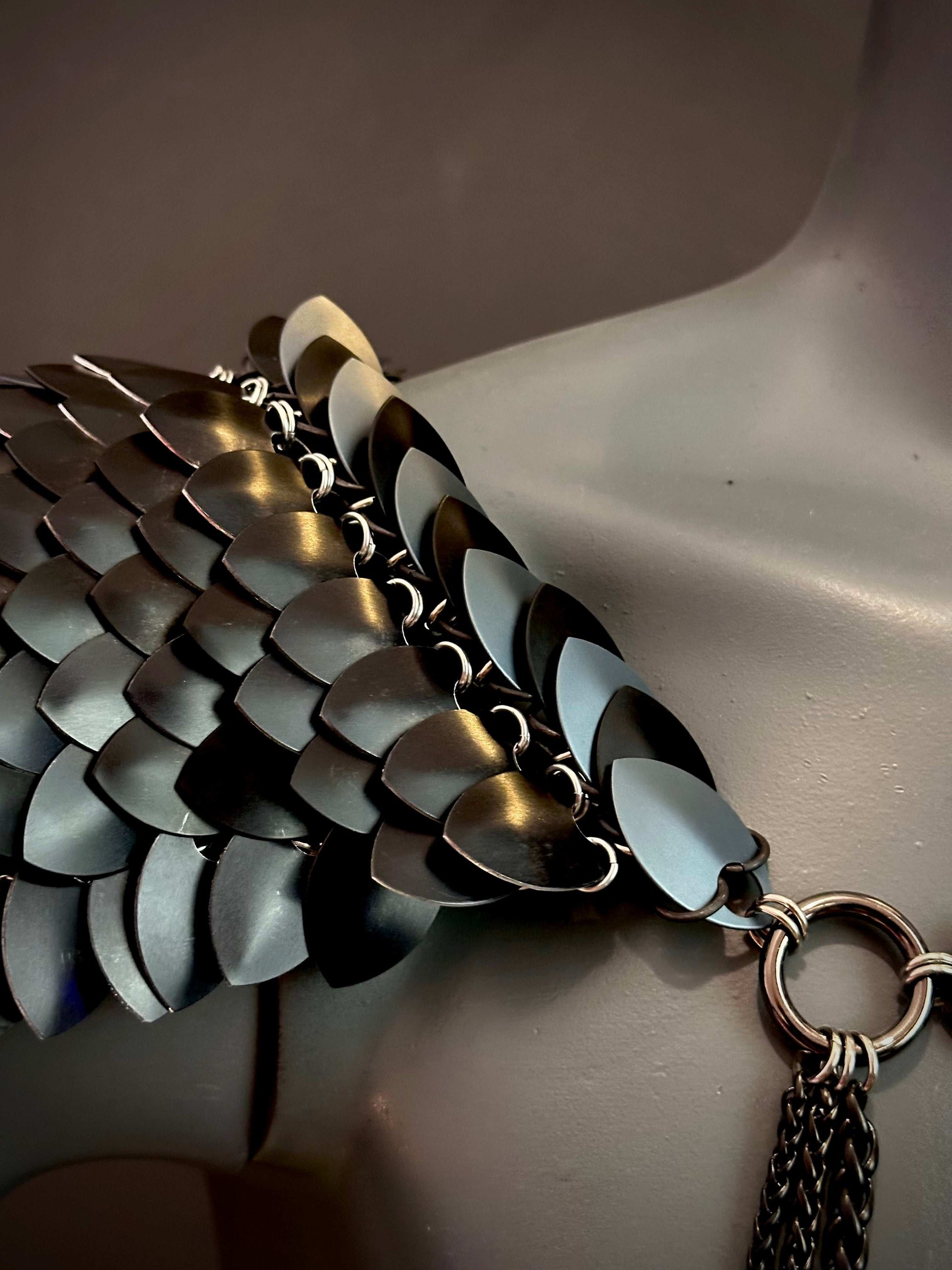 Metal chainmail necklace in black and silver with scale-like links, bold and edgy emotion