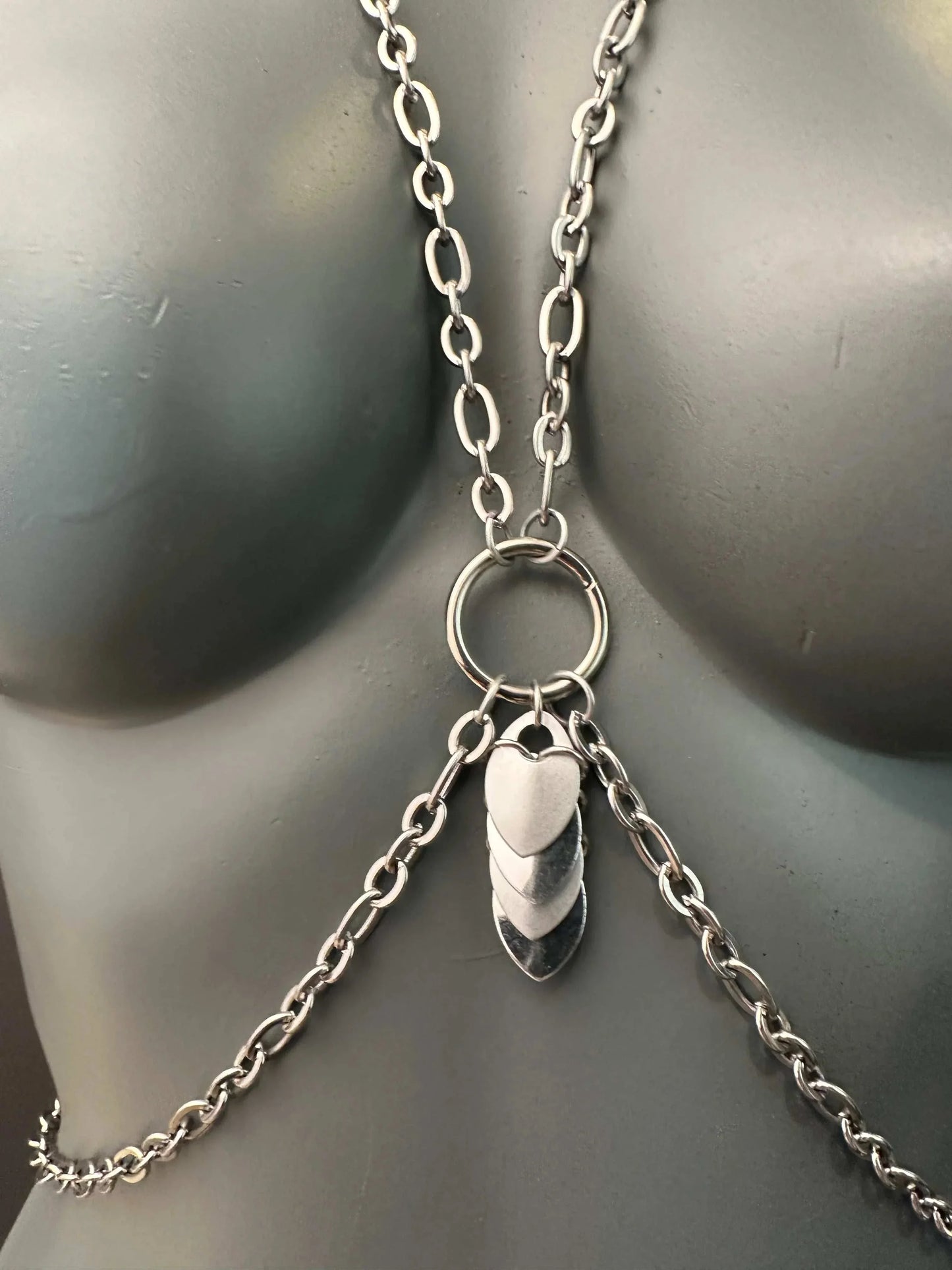Silver chain body harness with heart and leaf-shaped pendants, sleek metallic style, edgy feel