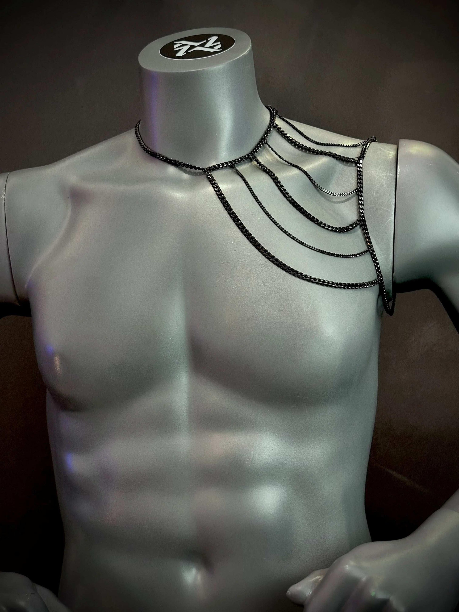 black chain shoulder jewelry on silver mannequin, edgy style, bold fashion statement