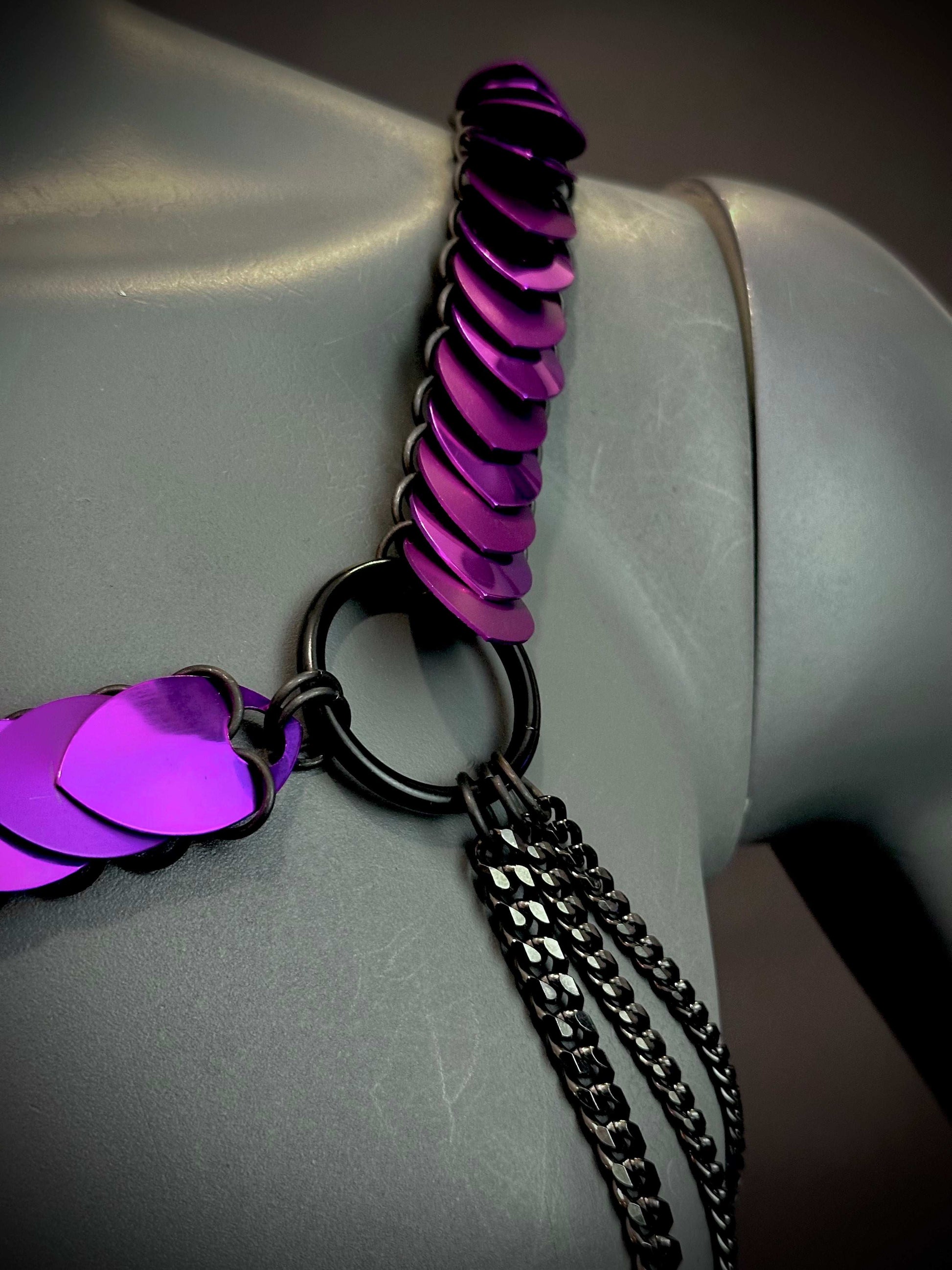 Chain necklace featuring vibrant purple scales and black metal rings and chains, edgy and bold style