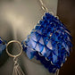Blue sequin chainmail bikini top with silver rings and tassels, bold and playful fashion