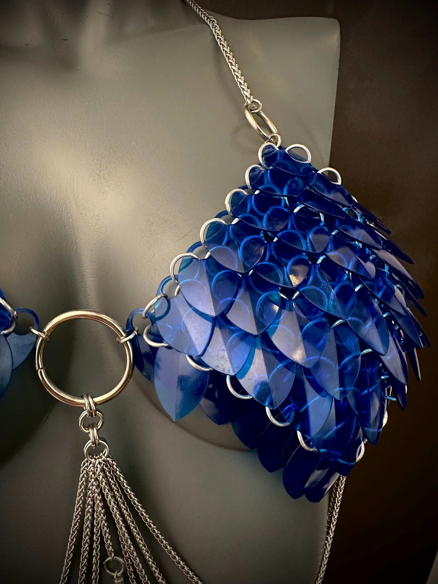 Blue sequin chainmail bikini top with silver rings and tassels, bold and playful fashion