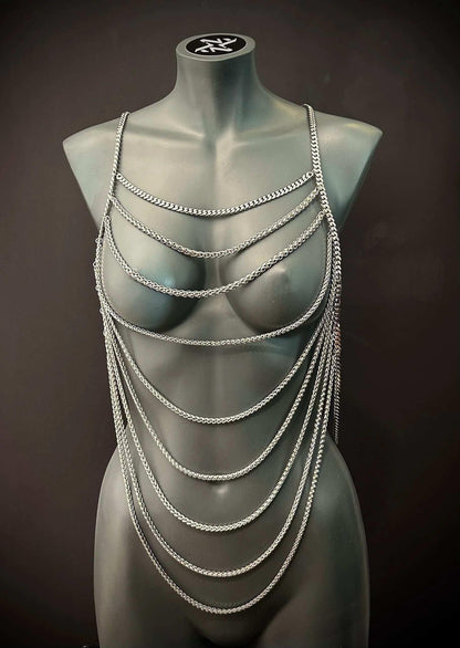 Silver chain body harness on gray mannequin, edgy style, bold and confident vibe