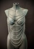Silver chain body harness on gray mannequin, edgy style, bold and confident vibe