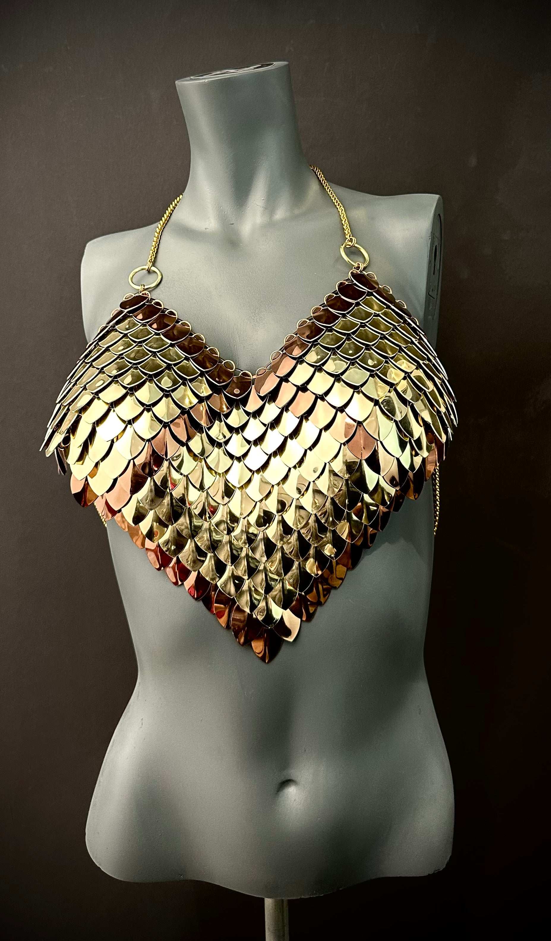 Metallic scale bra top in gold and bronze on a gray mannequin, bold and striking style