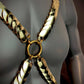 Gold metallic body harness with scale-like links on dark mannequin, bold and striking