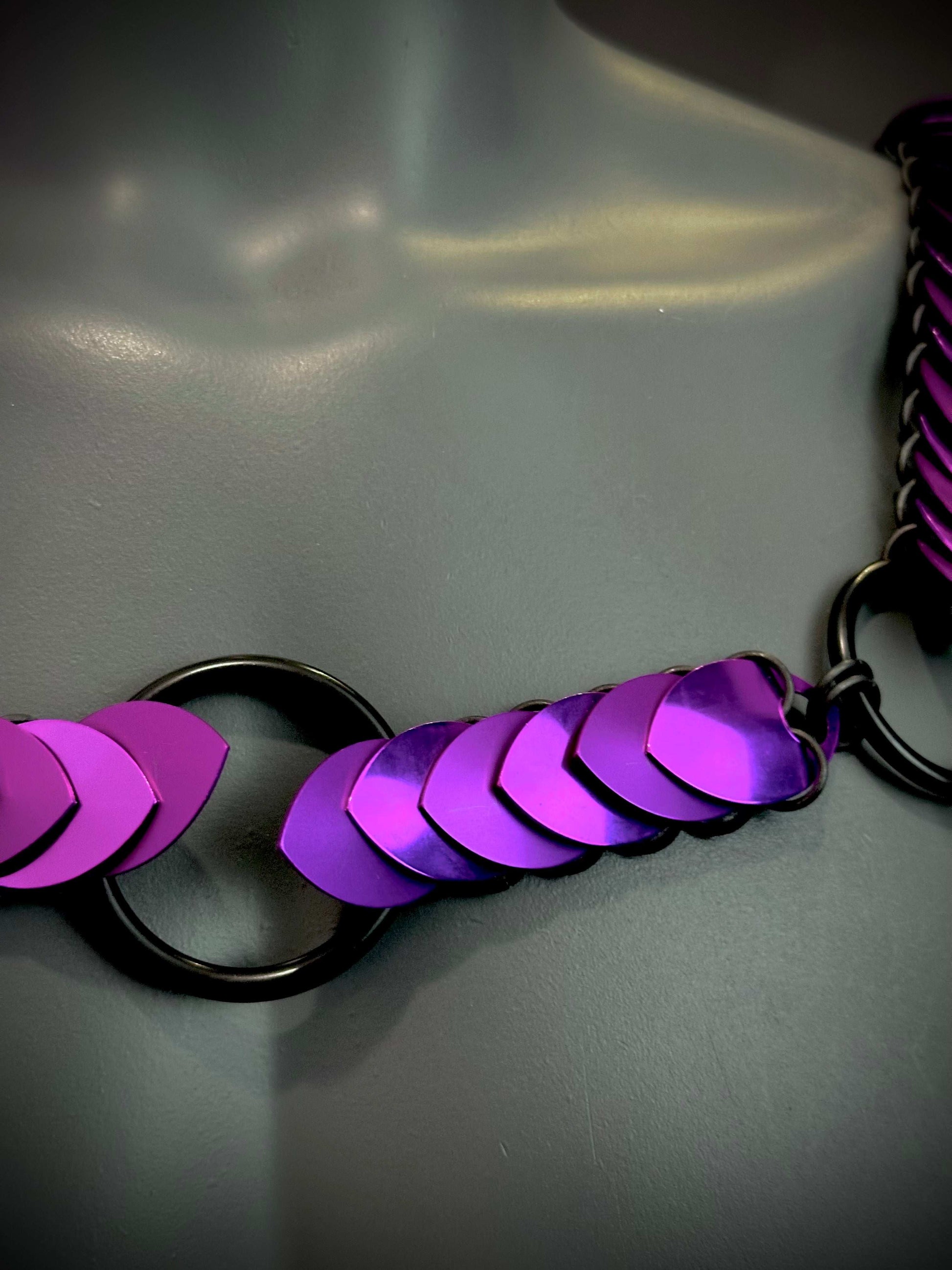 Purple metallic scale chainmail with black rings, shiny and bold, evoking strength and vibrancy