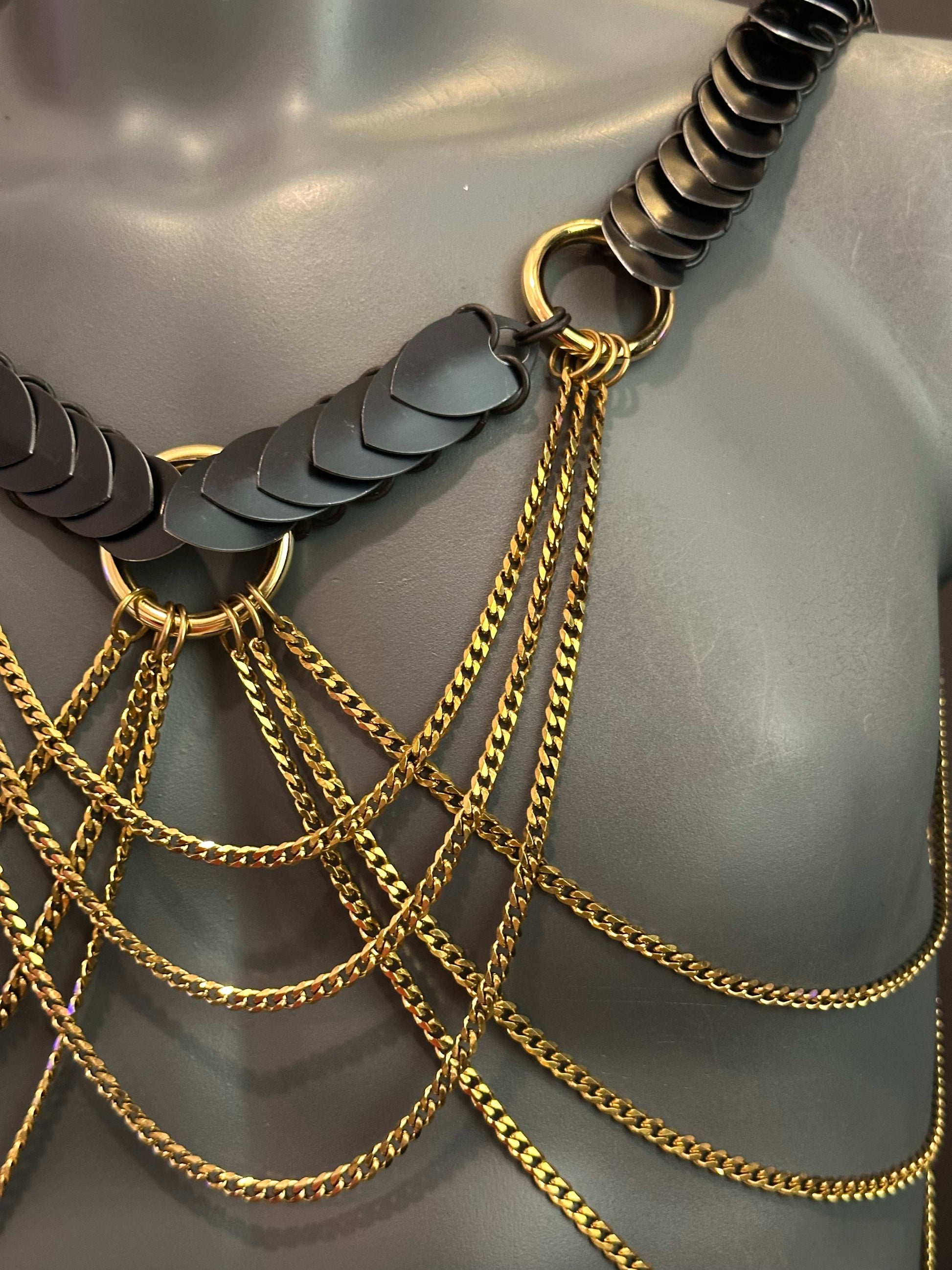 chain body jewelry with black metal scales and gold chains, stylish and bold, expressing confidence