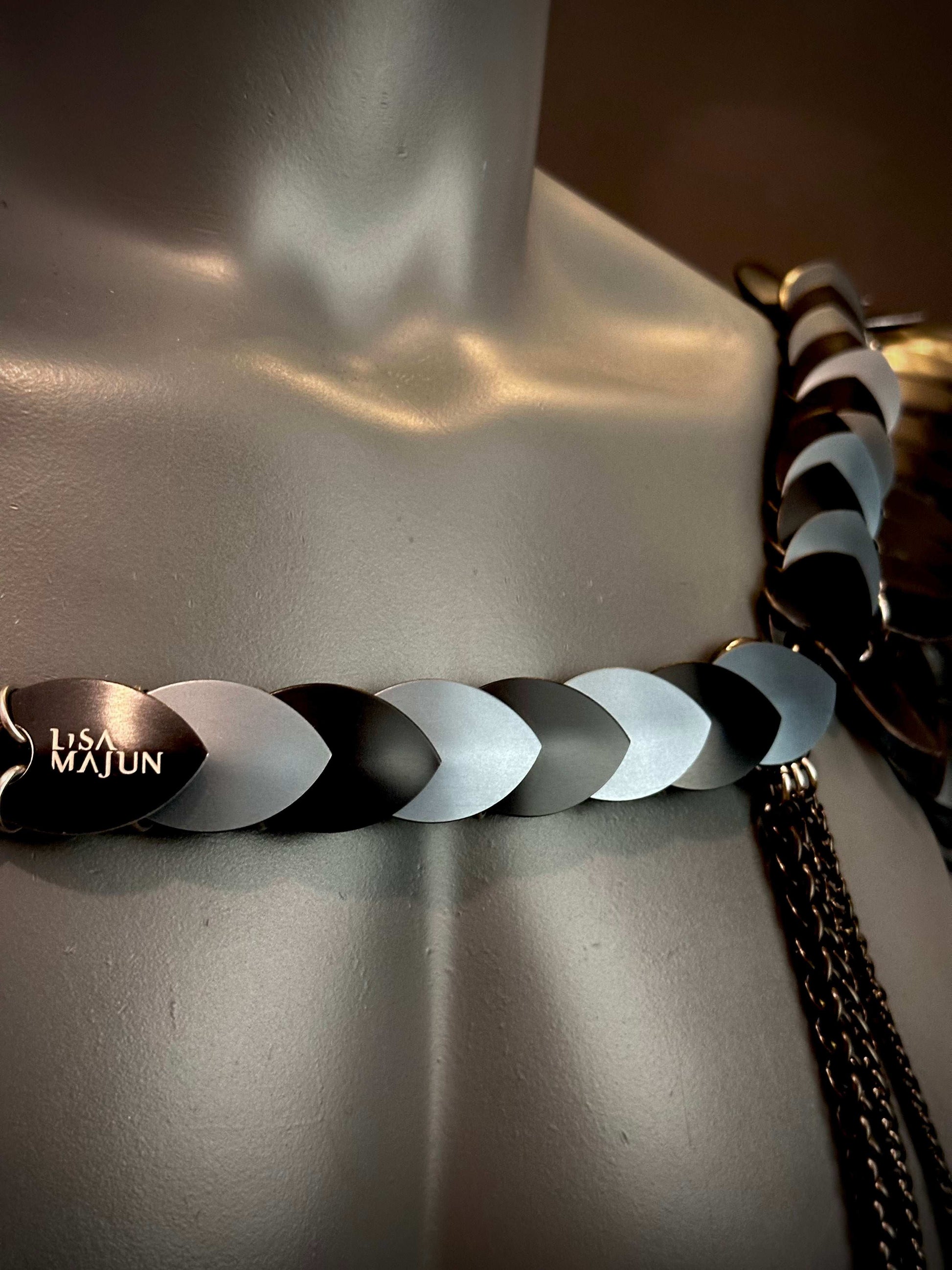 Lisa Majun metal belt with black and silver linked plates on a mannequin, stylish and bold
