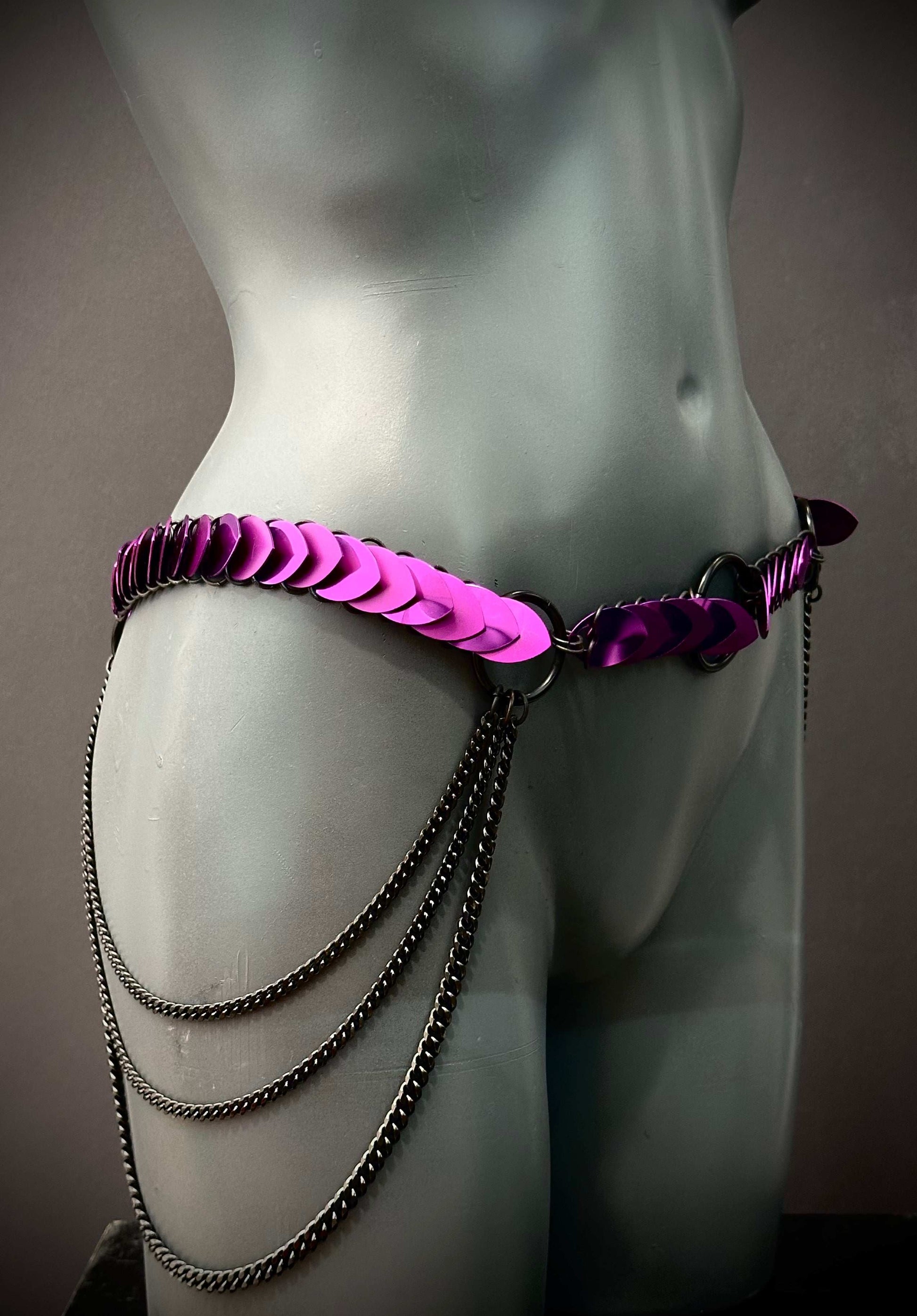 purple metal chain belt with scales on mannequin hip, edgy fashion, bold style, confident vibe