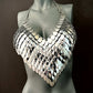 Silver metal scale halter top on gray mannequin, edgy futuristic fashion, bold confident style