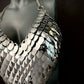silver metal scale chainmail halter top on black mannequin, edgy and bold fashion
