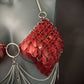 red scale bra with silver chains and spikes on grey mannequin, edgy wearable art, bold style