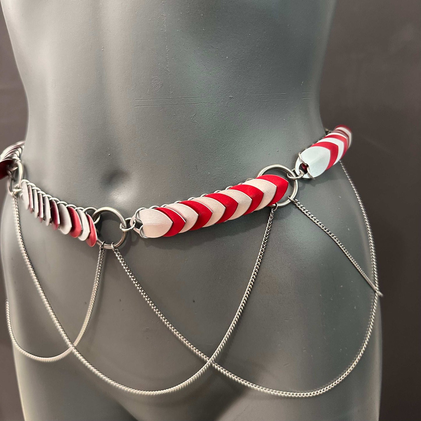 metal chain belt with red and white scales and hanging silver chains, modern and stylish, bold and edgy