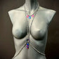 Silver body chain with pink and blue heart charms on gray mannequin, stylish and bold