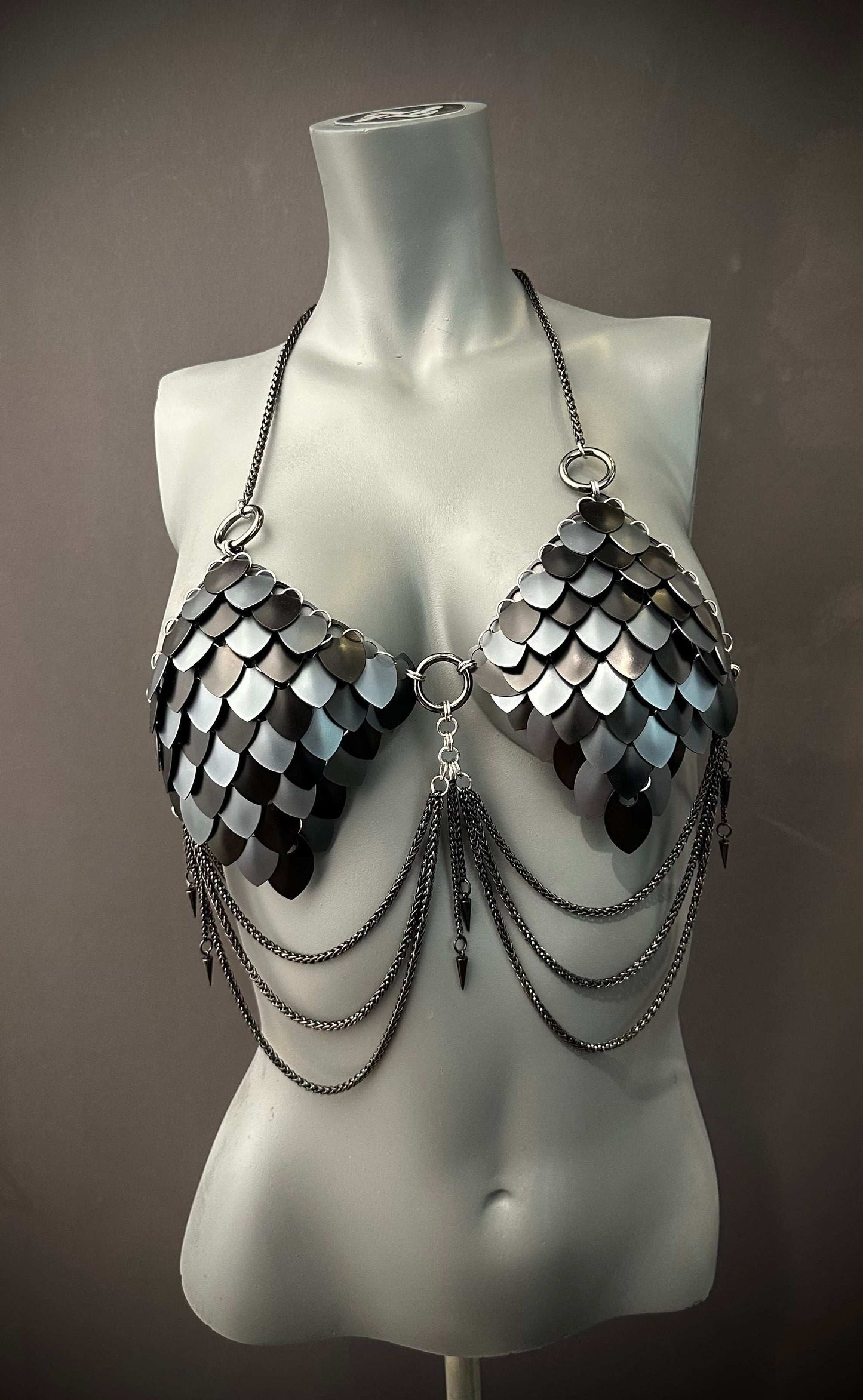 metal scale bra with black and silver metallic style and chain details on mannequin evoking edgy boldness