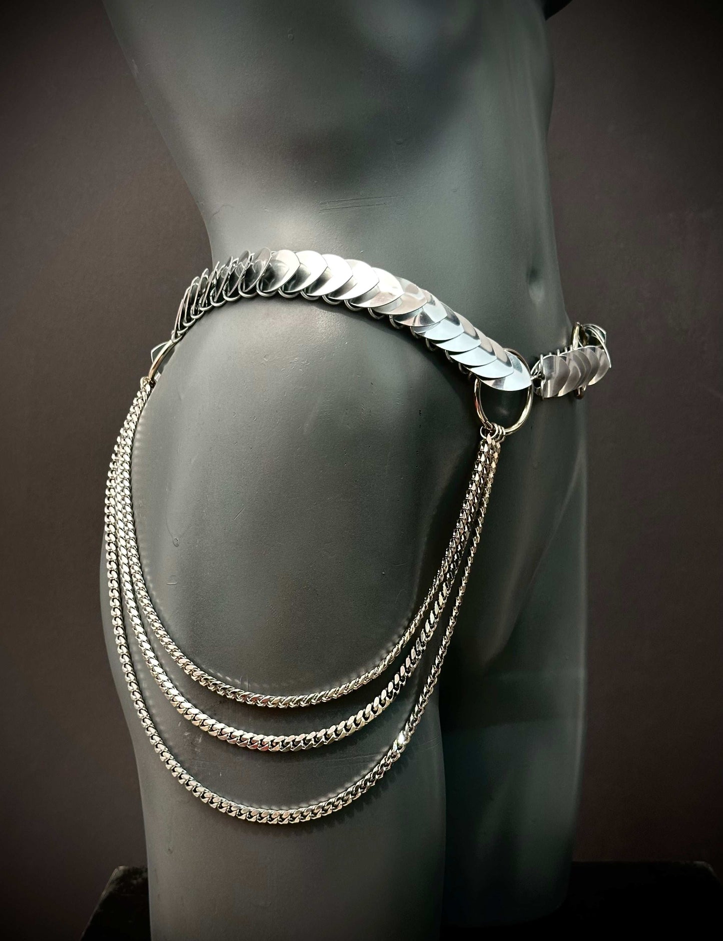Silver metal hip chain belt with layered chains on black mannequin, edgy and bold style