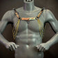 Men's gold metal chain harness with circular links on gray mannequin, bold edgy fashion style