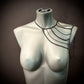 black chain shoulder harness on silver mannequin bust, edgy and modern style, bold emotion