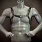 Silver mannequin wearing black metallic chain harness with sleek, edgy style, creating bold, confident vibe