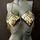 Gold metal scale bra with chains on gray mannequin, edgy style, bold confident vibes