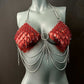 Red scale chainmail bikini top with silver chains on grey mannequin, edgy and bold fashion