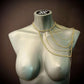 Gold body chain draped on gray mannequin, elegant style, bold and stylish look