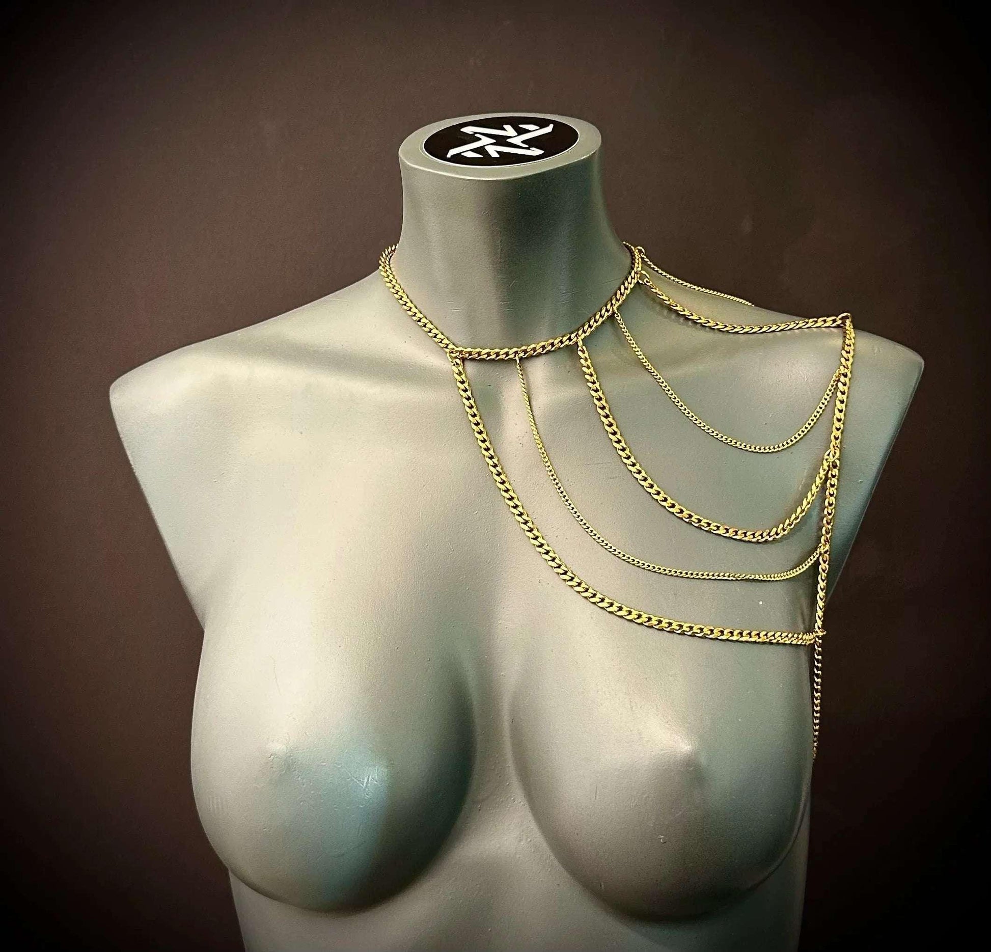 Gold body chain draped on gray mannequin, elegant style, bold and stylish look