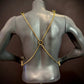 Gold chain harness on black mannequin back, stylish and edgy fashion accessory