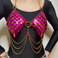 Metallic pink scale bra with gold chains styled over black top, bold and edgy feel