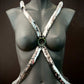 Product harness in reflective silver scale style on black mannequin, sleek and edgy mood