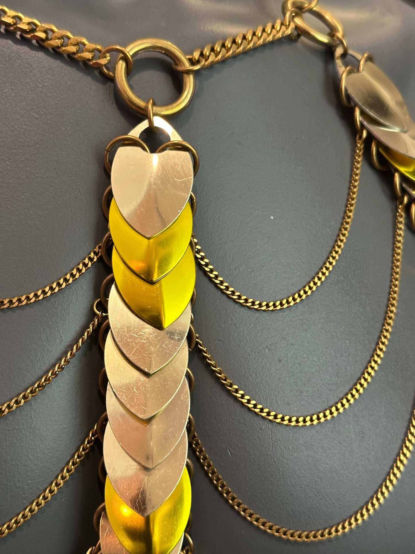 gold chain necklace with alternating yellow and gold metal leaf-shaped links, elegant and vibrant