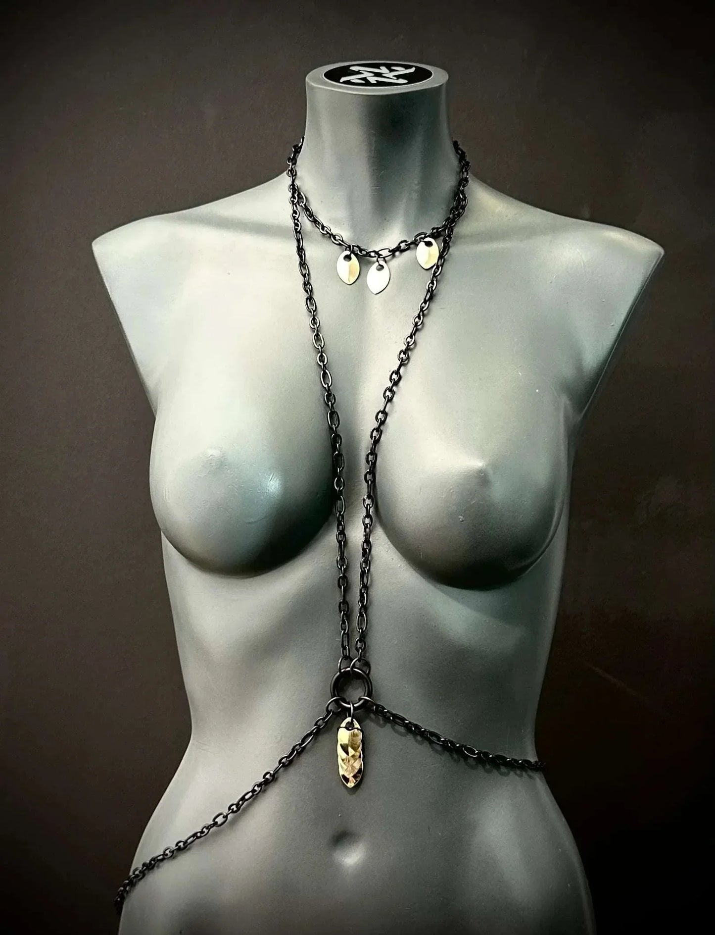 black metal body chain with gold pendants on gray mannequin, stylish and edgy