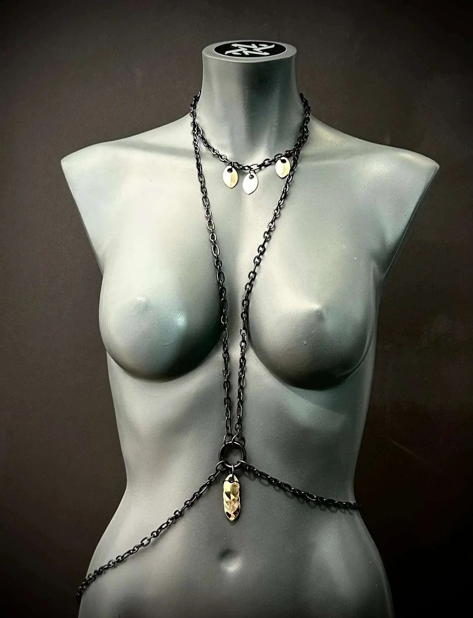black metal body chain with gold pendants on gray mannequin, stylish and edgy