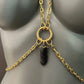 gold chain body harness with black heart charm on gray mannequin, edgy and bold fashion
