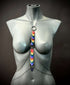 Rainbow heart chain body harness on gray mannequin, colorful and vibrant style, bold and expressive