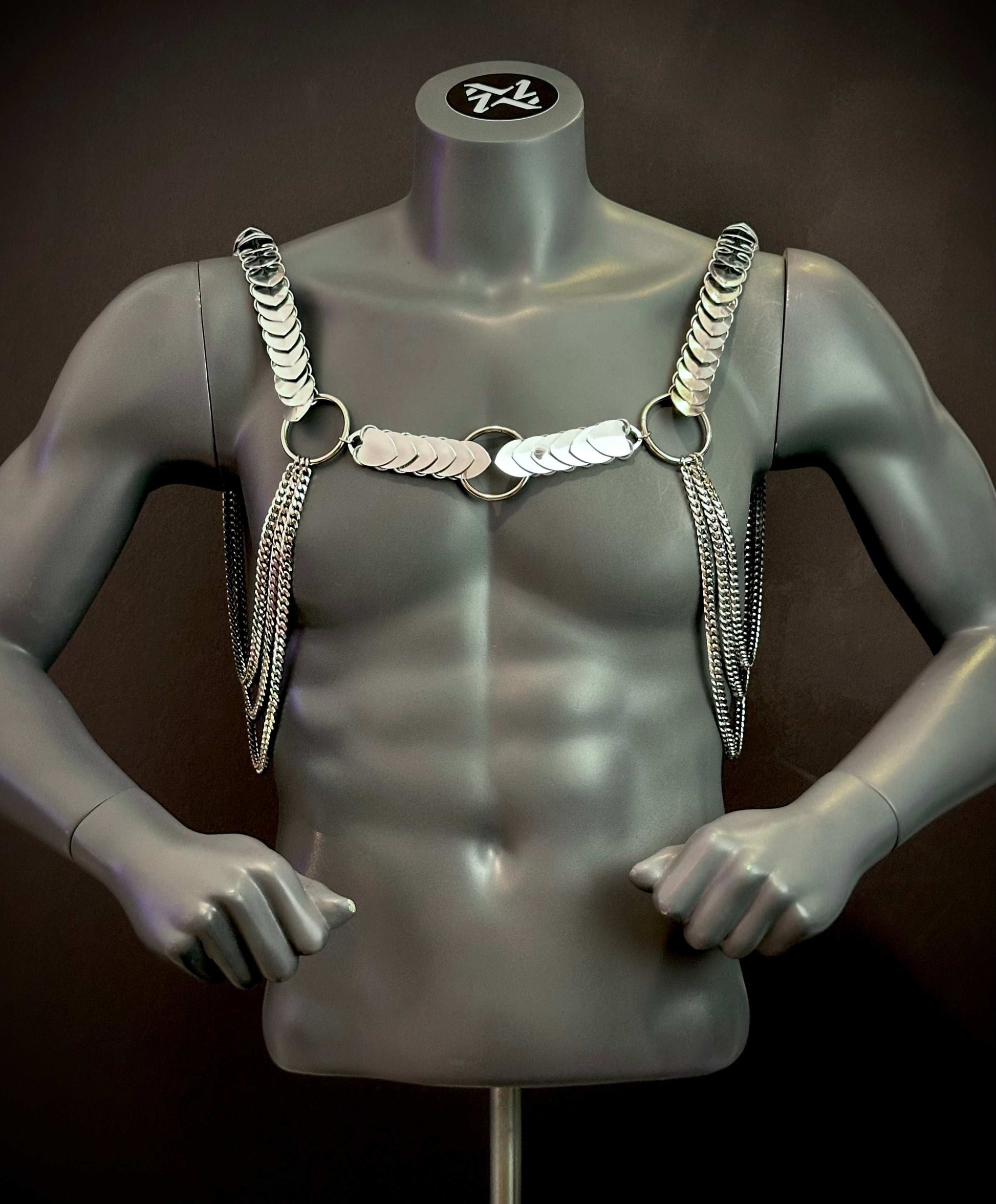 Silver chain harness with metallic discs and rings on dark gray mannequin, edgy and bold style