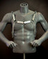 Silver chain harness with metallic discs and rings on dark gray mannequin, edgy and bold style