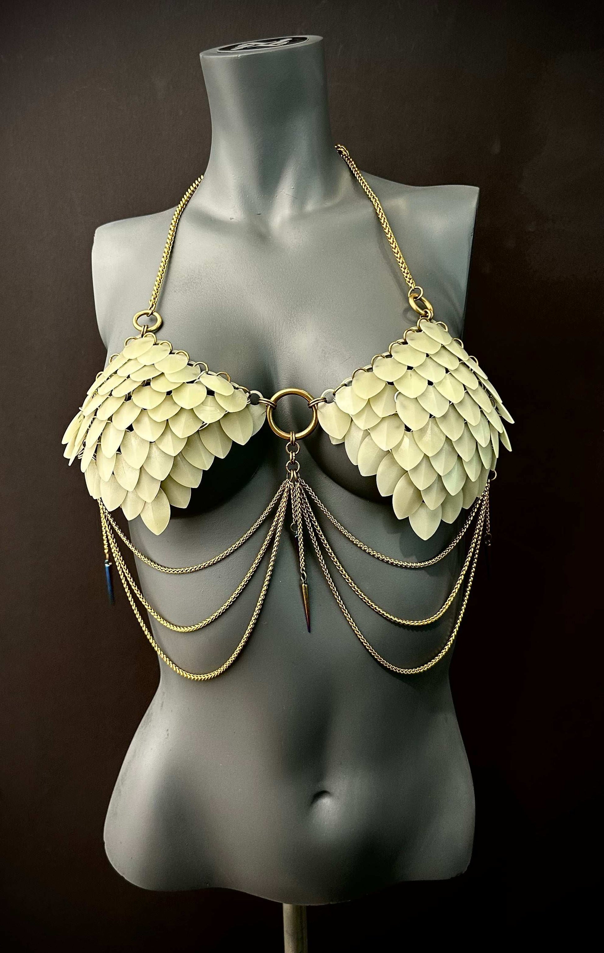 chain bra with beige scale-like plates and gold chains on black mannequin, edgy and bold style