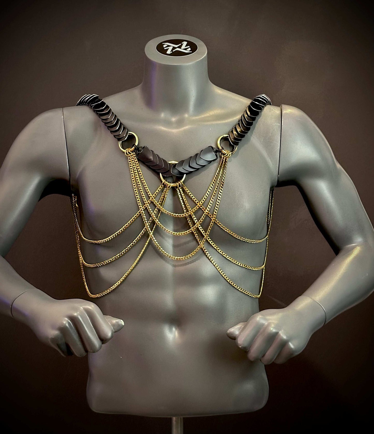 black leather harness with gold chains on gray mannequin, edgy style, bold confidence