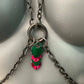 Chain necklace with silver metal links and green-pink heart-shaped charms, edgy and vibrant